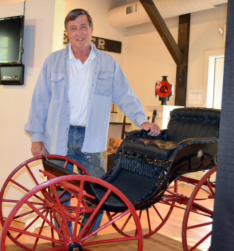 Keith Dauer, chairman of the exhibit with his wife, Sandy Senior-Dauer, is shown here with a wagon owned by Leonard Lieberman, on loan to the exhibit. Lieberman, a Chester native, recalls hearing that the wagon was used to help an elderly Chester woman get from Denison's store in town up to the church every Sunday (photo by Skip Hubbard).